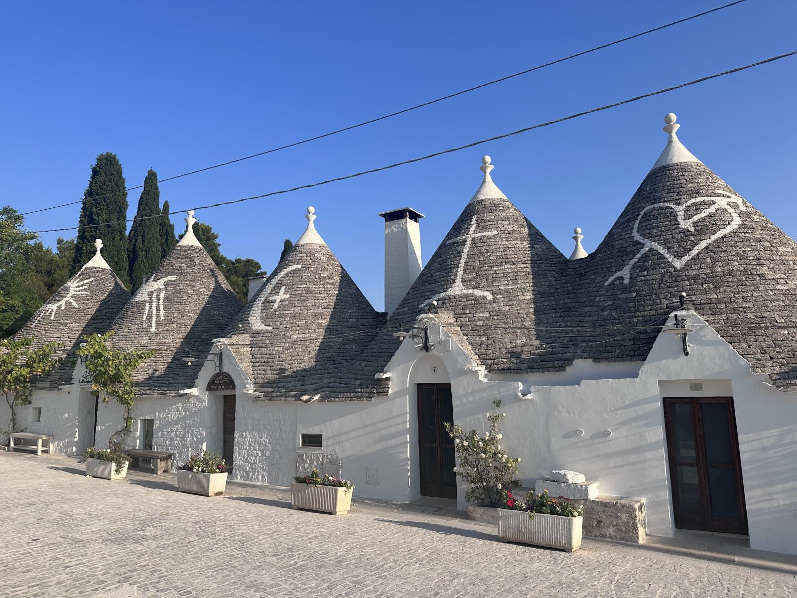italien_apulien_alberobello_reisetipps_sehenswuerdigkeiten_trulli_haeuser_painted_rooftop_5